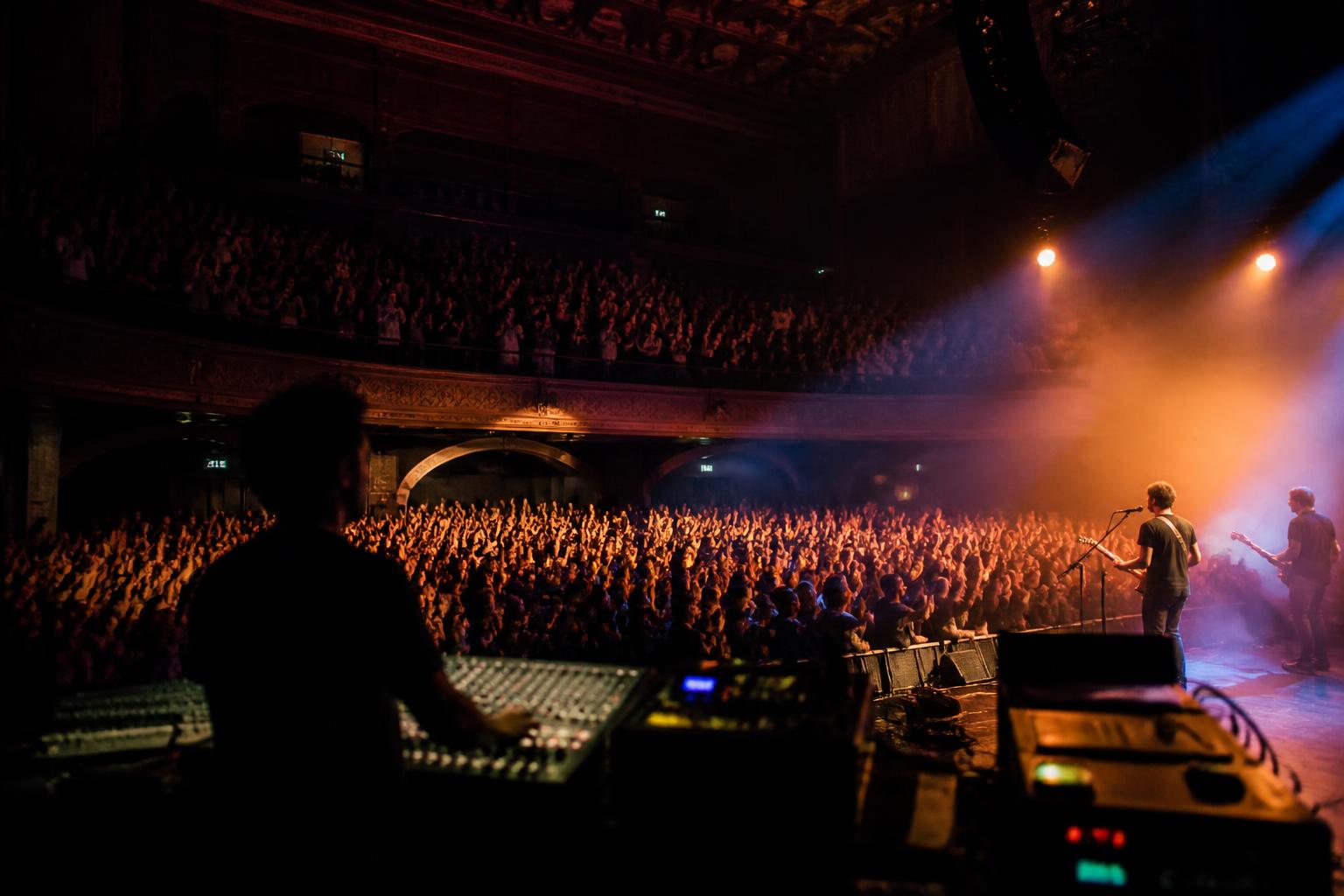 Live concert with front-of-house sound desk and audience